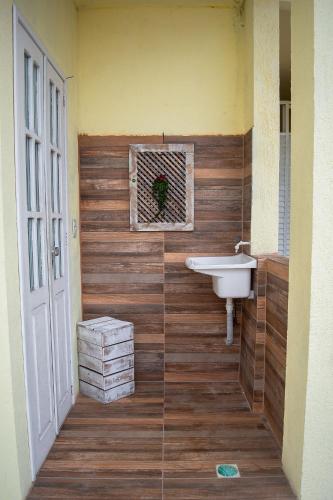 a bathroom with a sink and a wooden wall at Hermoso Apartamento, Centro de Búzios-5Min da Orla in Búzios