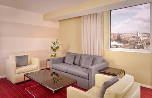 a living room with a couch and chairs and a window at Park Plaza Leeds in Leeds