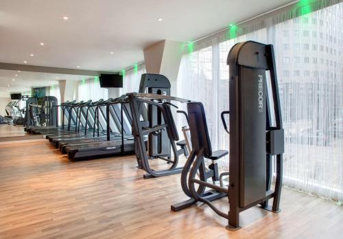 a gym with a row of treadmills and ellipticals at Park Plaza Leeds in Leeds