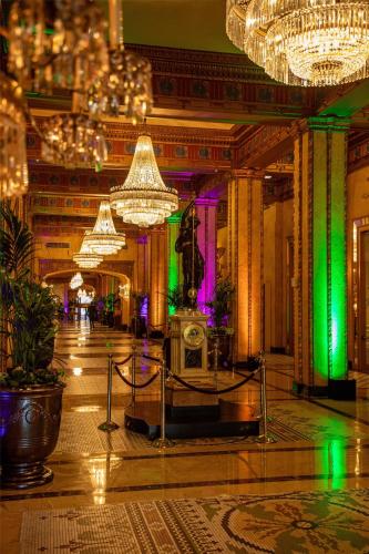 a large lobby with chandeliers and a room with at The Roosevelt Hotel New Orleans - Waldorf Astoria Hotels & Resorts in New Orleans