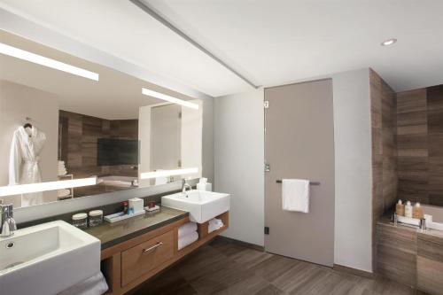 a bathroom with two sinks and a large mirror at Conrad New York Downtown in New York