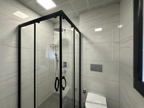 a shower with a glass door in a bathroom at Kaya Home Otel in Trabzon