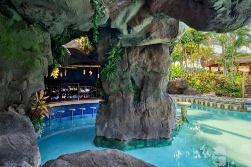 a resort pool with a rock wall and a bar at Ho'olei at Grand Wailea in Wailea