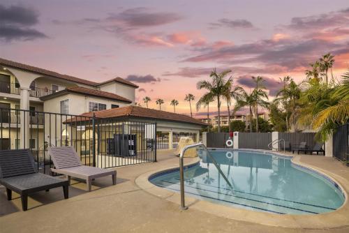 a swimming pool with two chairs and a house at Best Western San Diego Pacific Beach/Mission Bay in San Diego