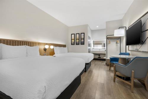 a hotel room with two beds and a desk at Best Western San Diego Pacific Beach/Mission Bay in San Diego