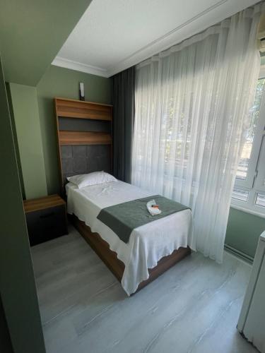 a bedroom with a bed and a large window at Başkent Otel in Mudanya