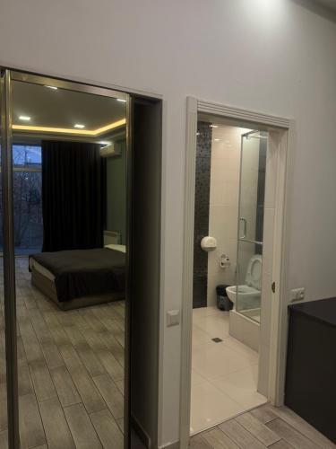 a bedroom with a bed and a bathroom with a mirror at Wave Inn boutique in Yerevan