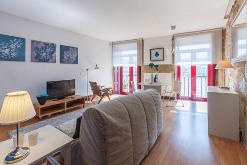 a living room with a couch and a tv at Go2oporto - Ribeira do Porto in Porto
