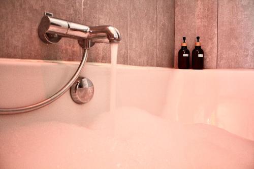 two bottles of wine sitting on top of a bath tub at Villa avec vue - terrasse - parking in Irigny
