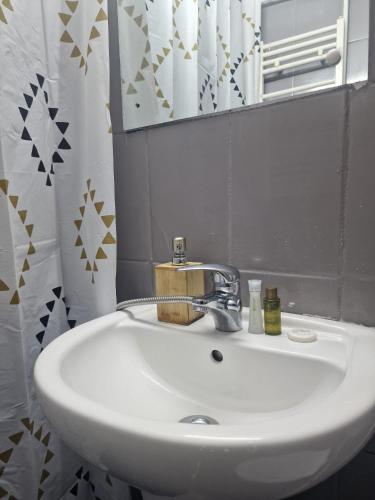 a white sink in a bathroom with a mirror at Eroilor Downtown Studio in Cluj-Napoca