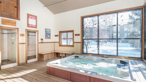 a hot tub in a room with a large window at Telluride Lodge 405 by AvantStay Close to Slopes Town in Telluride
