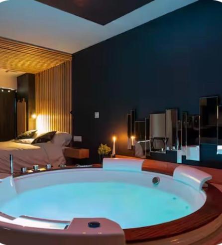 a large bath tub in a room with a bed at Loveroom Lens in Lens
