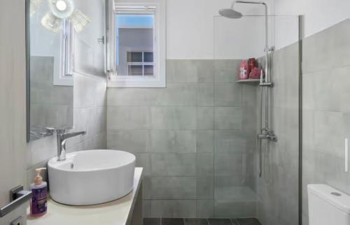 a bathroom with a sink and a shower at Sunset Realty in Ano Syros