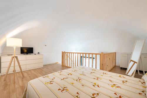 a bedroom with a bed and a television in it at Respiro di Chiaia in Procida