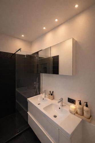 a white bathroom with a sink and a mirror at The White Boutique Loft in Antwerp
