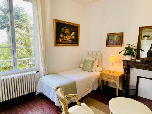 a small bedroom with a bed and a fireplace at Le Manoir des Doyens in Bayeux