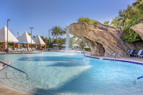 a swimming pool with a waterfall in a resort at Hilton Grand Vacations Club SeaWorld Orlando in Orlando