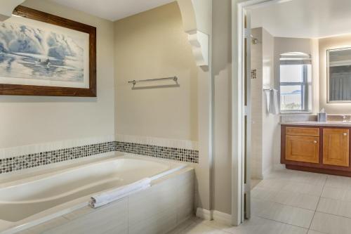 a white bathroom with a tub and a sink at Hilton Grand Vacations Club SeaWorld Orlando in Orlando