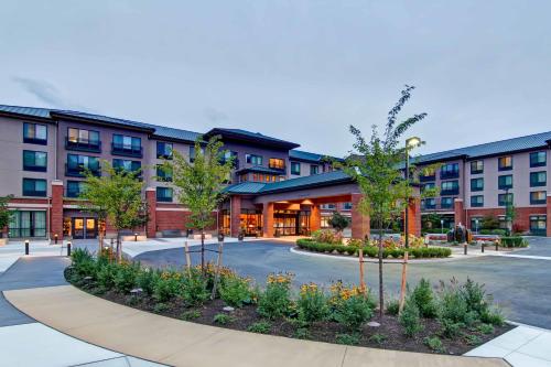 an apartment building with a courtyard with trees at Hilton Garden Inn Seattle/Issaquah in Issaquah