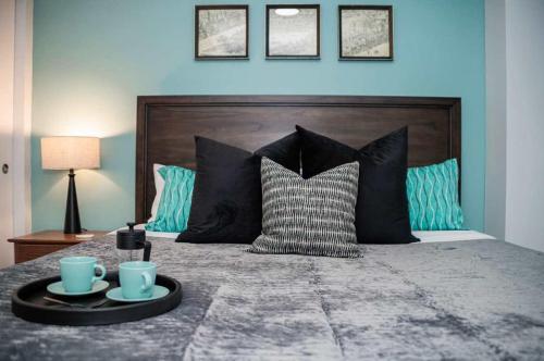 a bedroom with a bed with two cups and pillows at Fun Cozy 1 Br King Apts - 1 25 Mile Walk to TIAA Bnk Fld in Jacksonville
