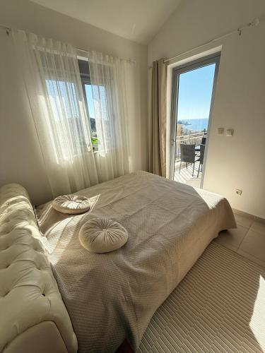 a bedroom with a large bed with two pillows on it at Petrovac Pearl Apartment in Petrovac na Moru
