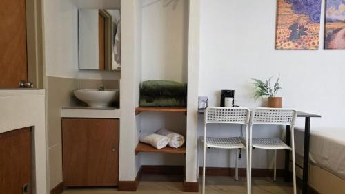 a bathroom with a sink and a table and two chairs at ABC-53 Housing in Medellín