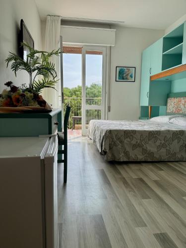 un dormitorio con una cama, una mesa y una ventana en Hotel El Paso, en Lido di Jesolo