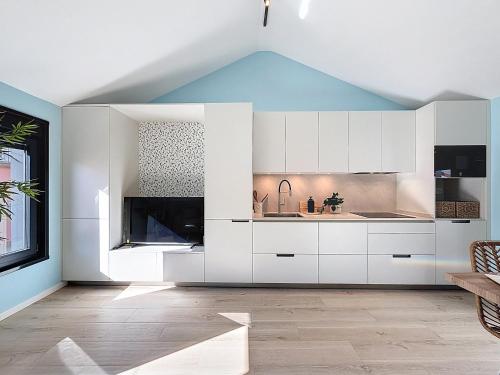 a kitchen with white cabinets and a blue ceiling at Casa PedraParda in O Grove