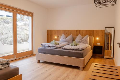 a bedroom with a bed and a large window at Alps Living Söll in Söll