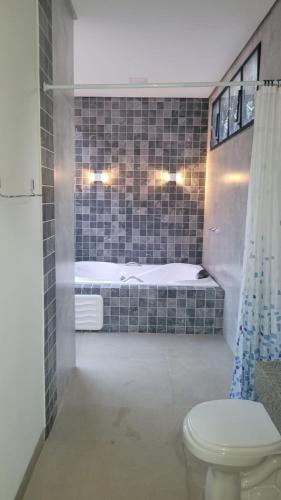 a bathroom with a bed and a toilet in a room at Camisão CasaJuMa Pixixi in Aquidauana