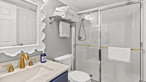 a bathroom with a shower and a toilet and a sink at Beachfront Breeze by AvantStay in Panama City Beach