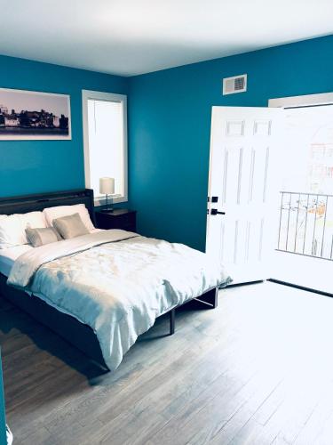 a bedroom with a bed with a blue wall at Temperly Heavon in Newark