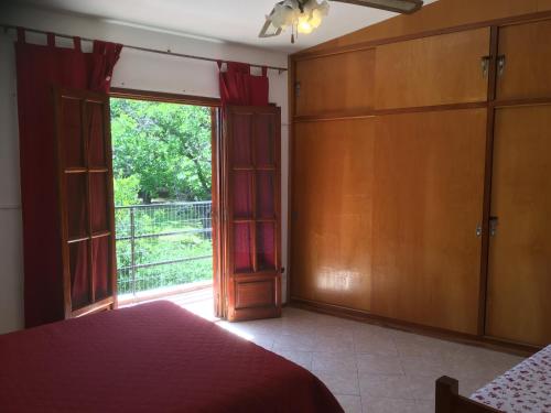 a bedroom with a bed and a large window at Unsleben in Villa Carlos Paz