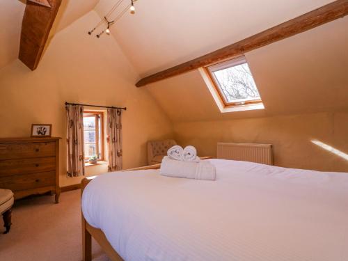a bedroom with a white bed and a window at Elm View in Chipping Campden