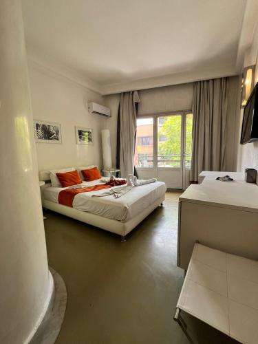 a bedroom with two beds and a window at La Renaissance hôtel Marrakech in Marrakesh