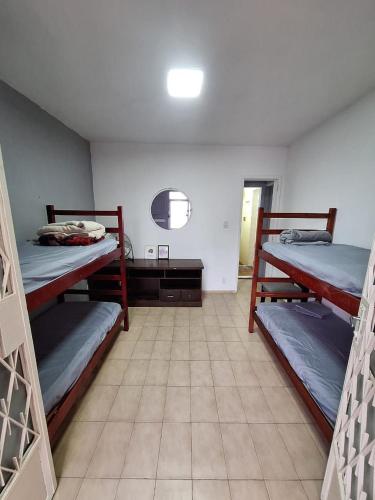 a room with three bunk beds and a mirror at Casa com Quarto Duplo com Banheiro Privativo in Rio de Janeiro