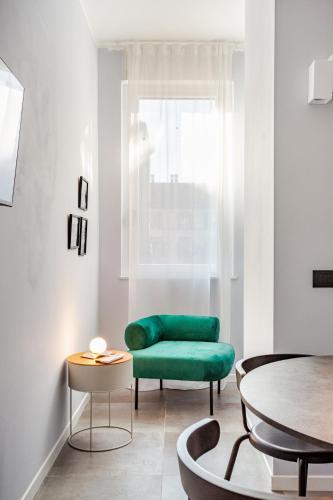 a living room with a green couch and a table at Suite Andrea-Luxury Central Suite in Bergamo