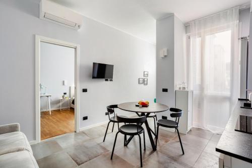 a white living room with a table and chairs at Suite Andrea-Luxury Central Suite in Bergamo