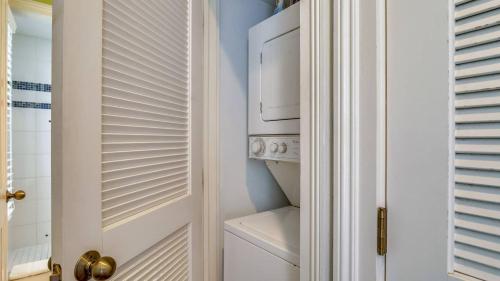 a white laundry room with a washer and dryer at Paradise Place by AvantStay Key West Old Town Condo w Shared Pool in Key West