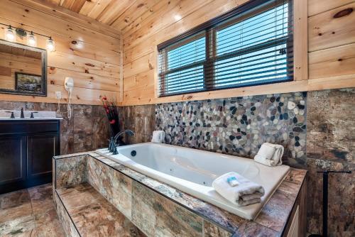a bathroom with a tub and a sink at Massive Cabin Indoor Pool Driving Simulators Sleeps 20 in Gatlinburg