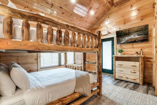 a bedroom with a bunk bed in a log cabin at Massive Cabin Indoor Pool Driving Simulators Sleeps 20 in Gatlinburg