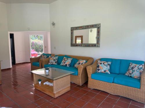 a living room with blue couches and a mirror at Casa Los Cardenales Ticuman in Ticumán