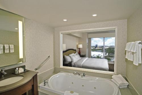 a bathroom with a bath tub and a bedroom at Hilton Niagara Falls/ Fallsview Hotel and Suites in Niagara Falls