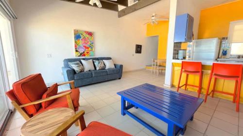 a living room with a couch and a table and chairs at Cozy & Colorful Beachfront Condo Las Olas II 4 in Puerto Peñasco