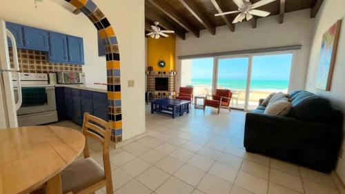 a kitchen and living room with a view of the ocean at Cozy & Colorful Beachfront Condo Las Olas II 4 in Puerto Peñasco
