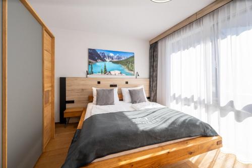 a bedroom with a bed and a large window at Moderne Wohnung mit einer wunderschönen Aussicht in der Residenz Silvretta, inkl Silvretta Card Premium in See