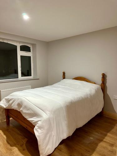 a bedroom with a large white bed with a window at Ocean view apartment in Tralee