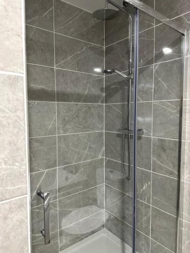a shower with a glass door in a bathroom at Ocean view apartment in Tralee