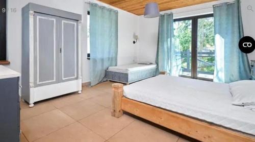 a bedroom with a bed and a window at Willa Bosmański Zakątek in Tałty