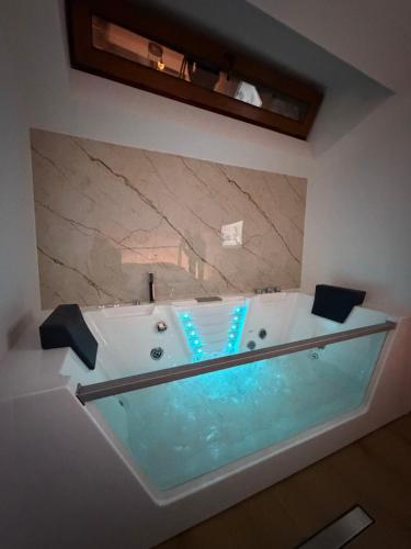 a bathroom with a bath tub with at EPICENTAR Luxury Jacuzzi & Sauna Apartment in Baščaršija - Private Spa Experience in Sarajevo